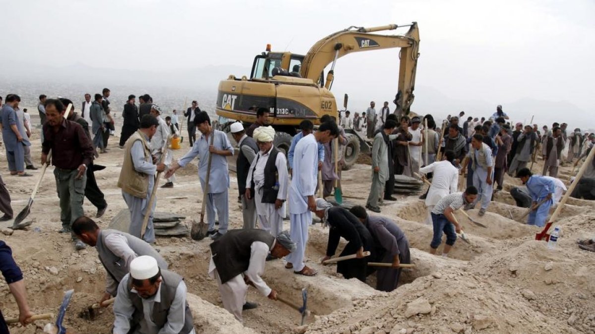 Decenas de personas han acudido a un cementerio de Kabul a cavar tumbas para las víctimas del atentado.-JAWAD JALALI / EFE