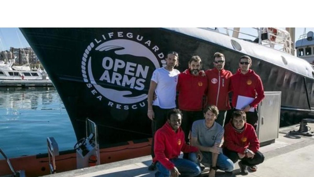 La tripulación integrada por miembros de la oenegé Open Arms junto al barco 'Golfo Azzurro' en el Port Vell de Barcelona.-JOAN CORTADELLAS