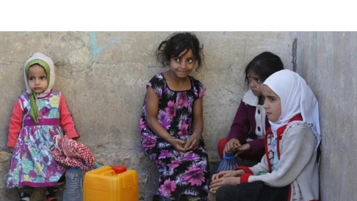 Niñas yemenís esperan para coger agua en una fuente potable en Saná.-EFE