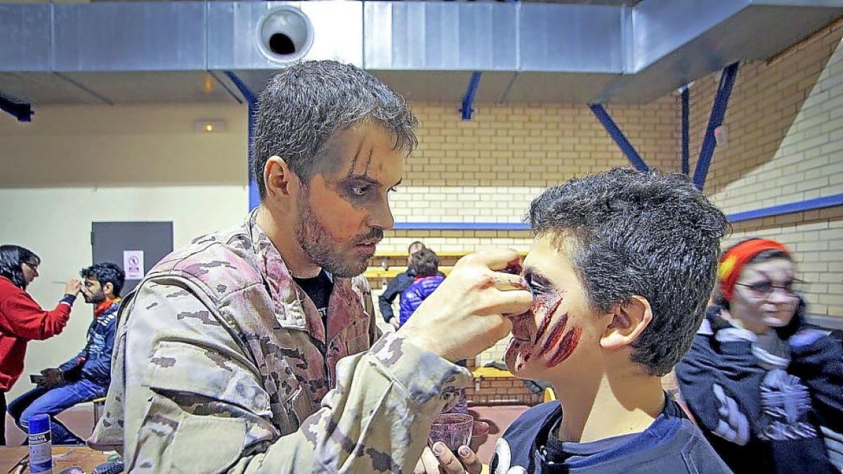 Un miembro de la organización maquilla a uno de los participantes de una anterior edición de la ‘Survival Zombie’.-WRG