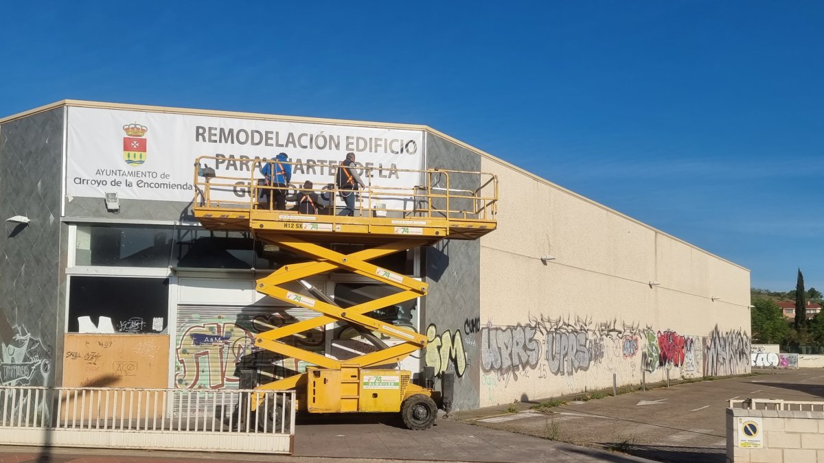 Instalación de la lona informativa en la fachada de la nave que albergará el futuro cuartel de la Guardia Civil en Arroyo de la Encomienda, imagen de archivo - PHOTOGENIC