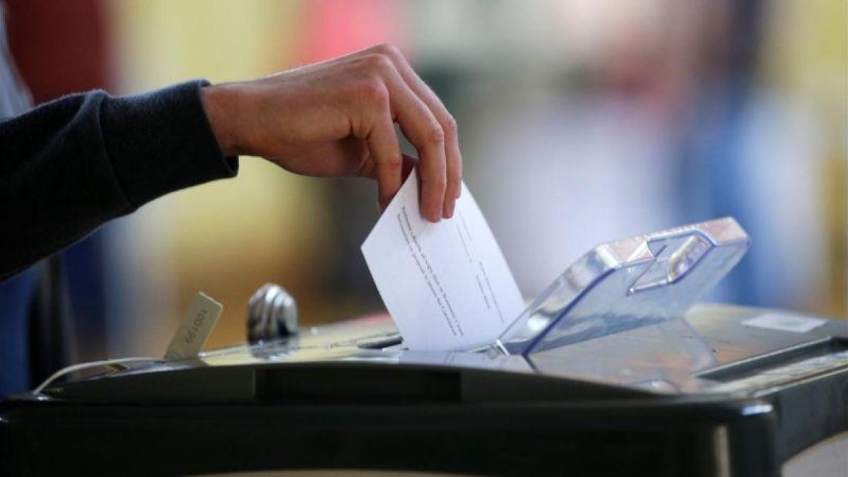 Un votante introduce la papeleta en el referéndum en Irlanda sobre la reforma del aborto.-REUTERS / MAX ROSSI