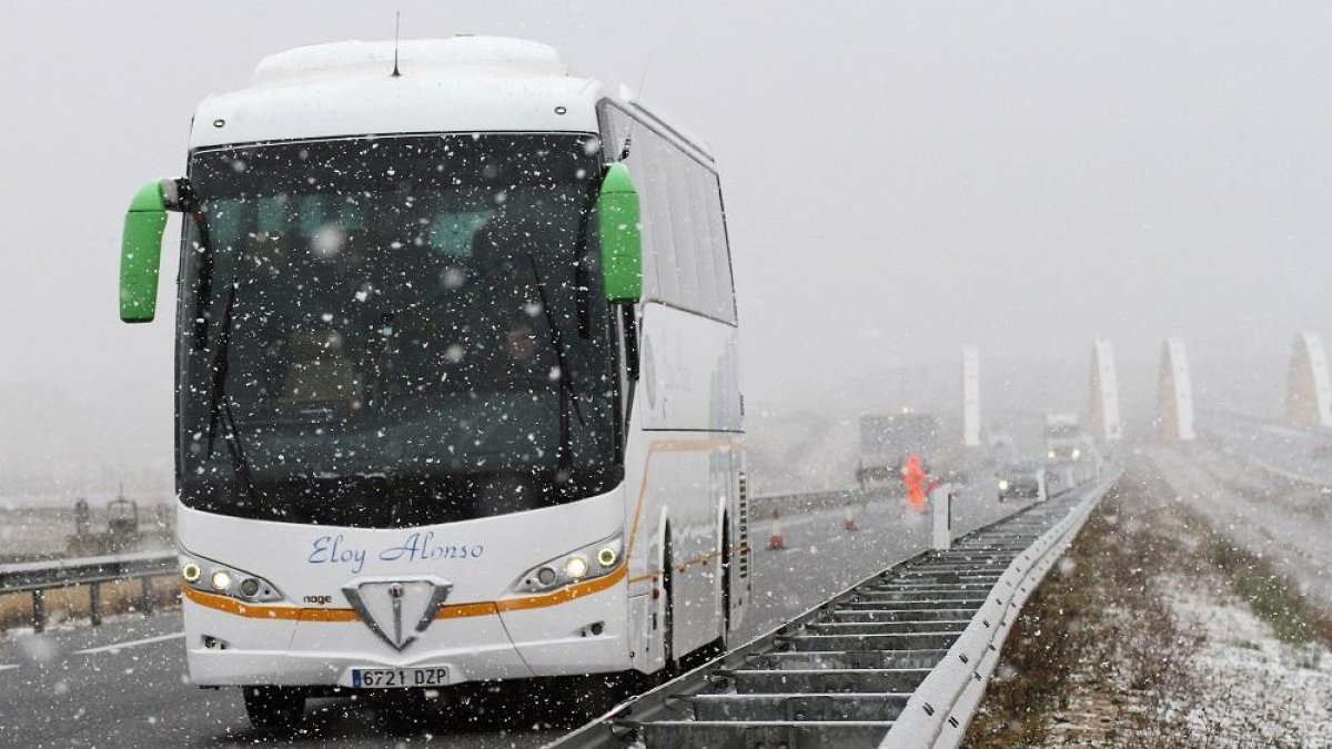 Un autobús circula durante una nevada en una foto de archivo.-ICAL