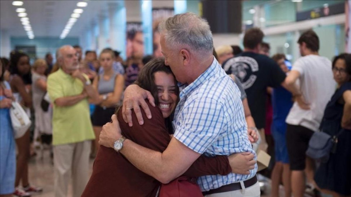 Un padre abraza a su hija en El Prat a su llegada de Estambul.-AFP / JOSEP LAGO