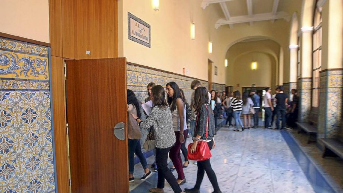 Varios jóvenes se adentran en una de las aulas de la Facultad de Derecho de la Universidad de Valladolid.-ICAL