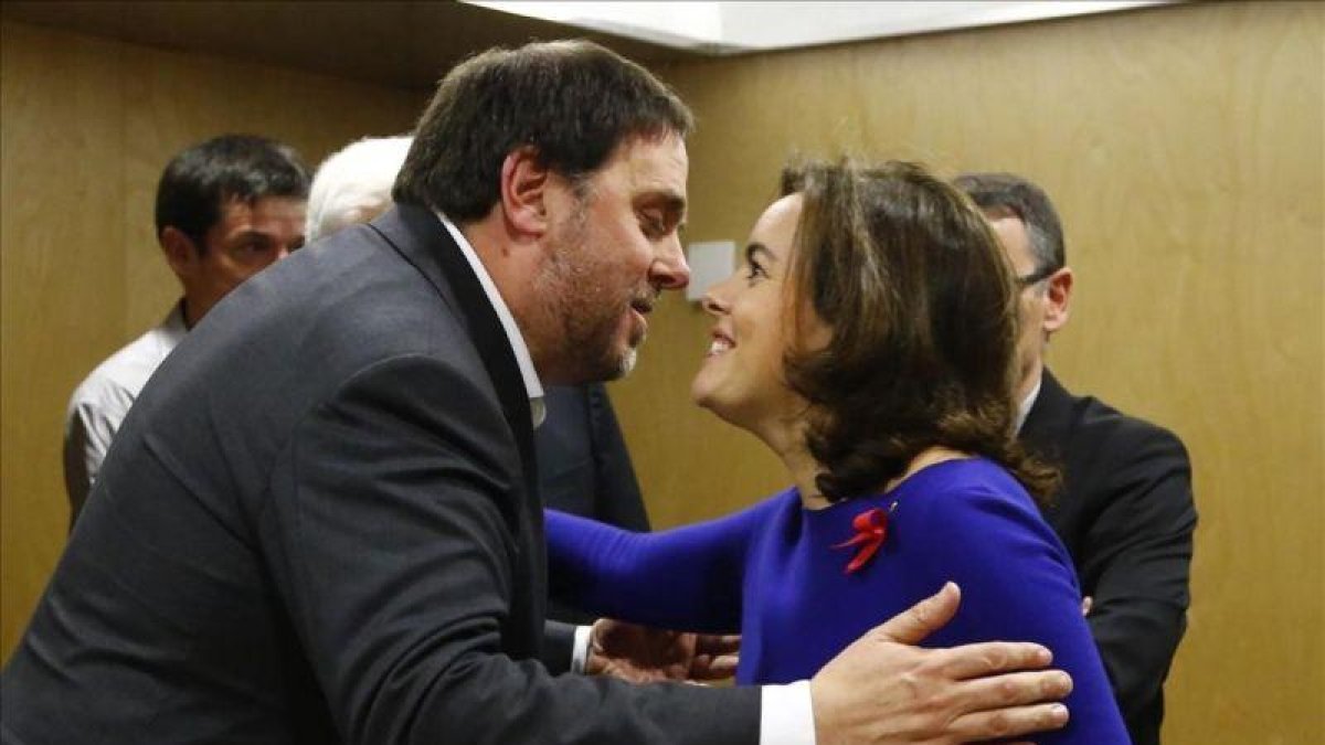 Santamaría y Junqueras se saludan antes de empezar la reunión del Consejo de Política Fiscal y Financiera.-AGUSTIN CATALAN