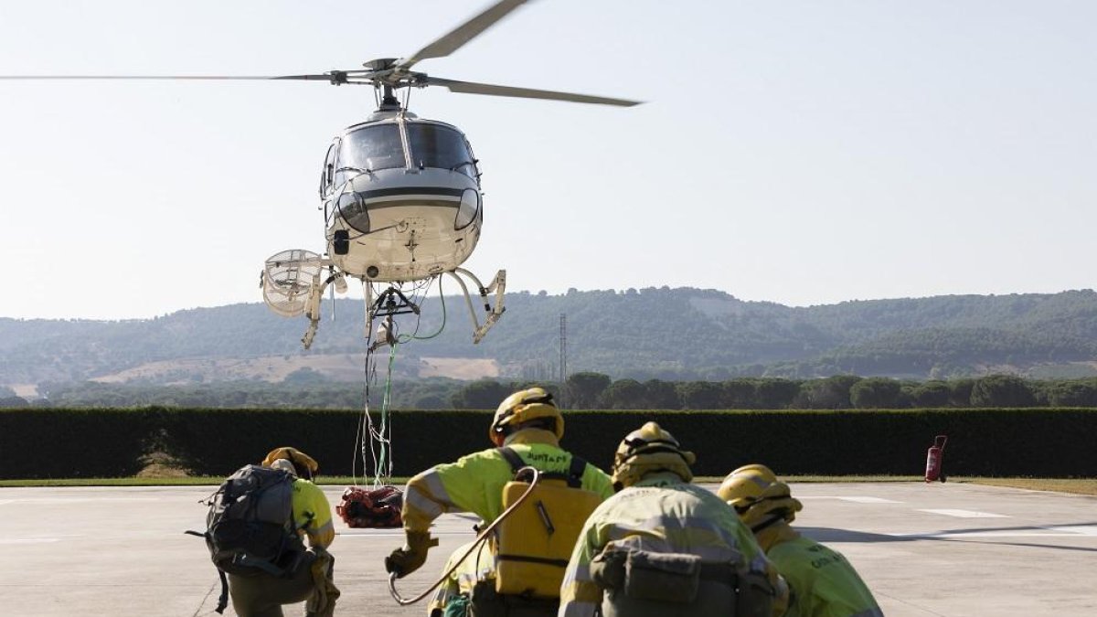 El helicóptero se eleva y los miembros aguardan con sus herramientas en un simulacro en la base de Quintanilla.-PABLO REQUEJO