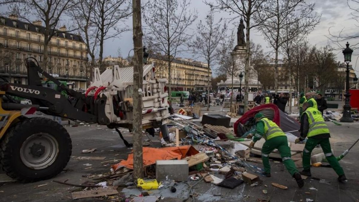 Empleados municipales limpian la plaza de la República después de que los gendarmes evacuaran a los indignados, este lunes, en París.-EFE / IAN LANGSDON