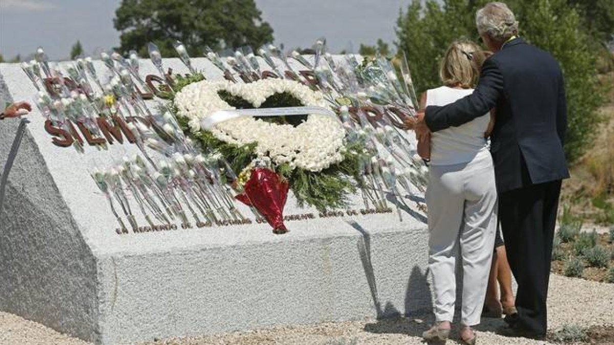 Familiares de las víctimas, ante el monolito de homenaje a las víctimas.-EFE / JUAN CARLOS HIDALGO