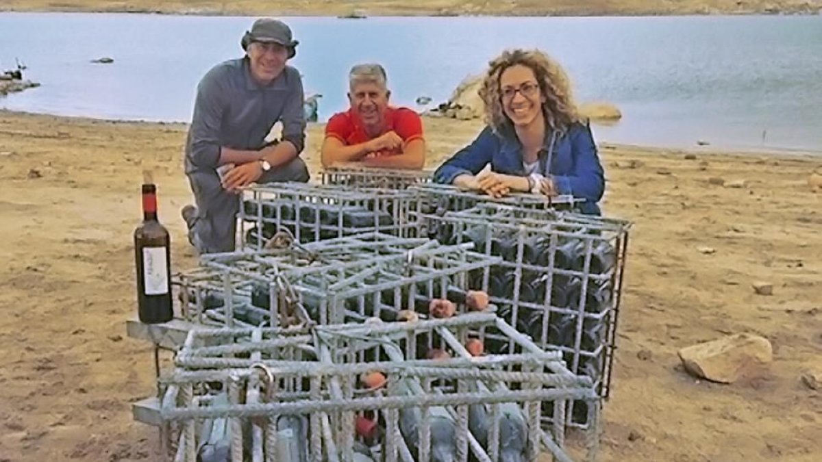 Los hermanos Luis, Enrique y Almudena Castelló con las botellas recién extraídas del agua.-L.P.