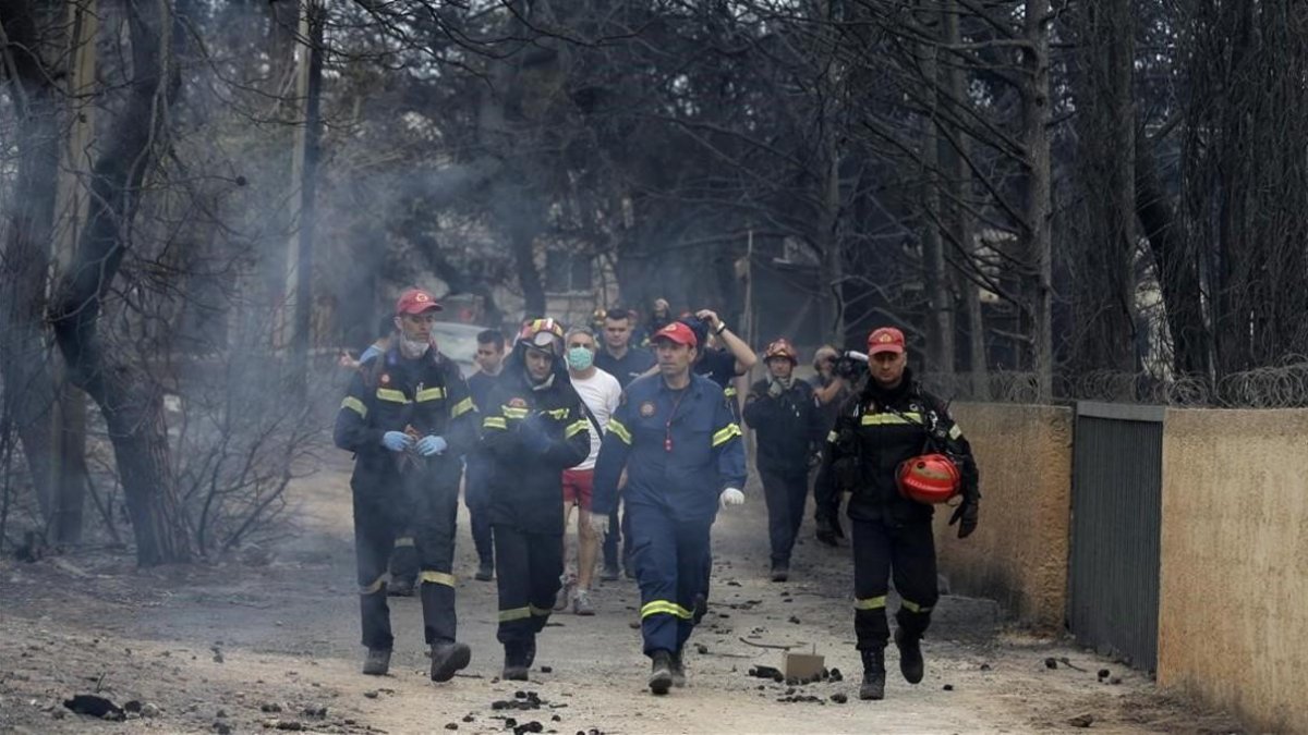 Un grupo de bomberos en una calle de Mati. /-AP / THANASSIS STAVRAKIS