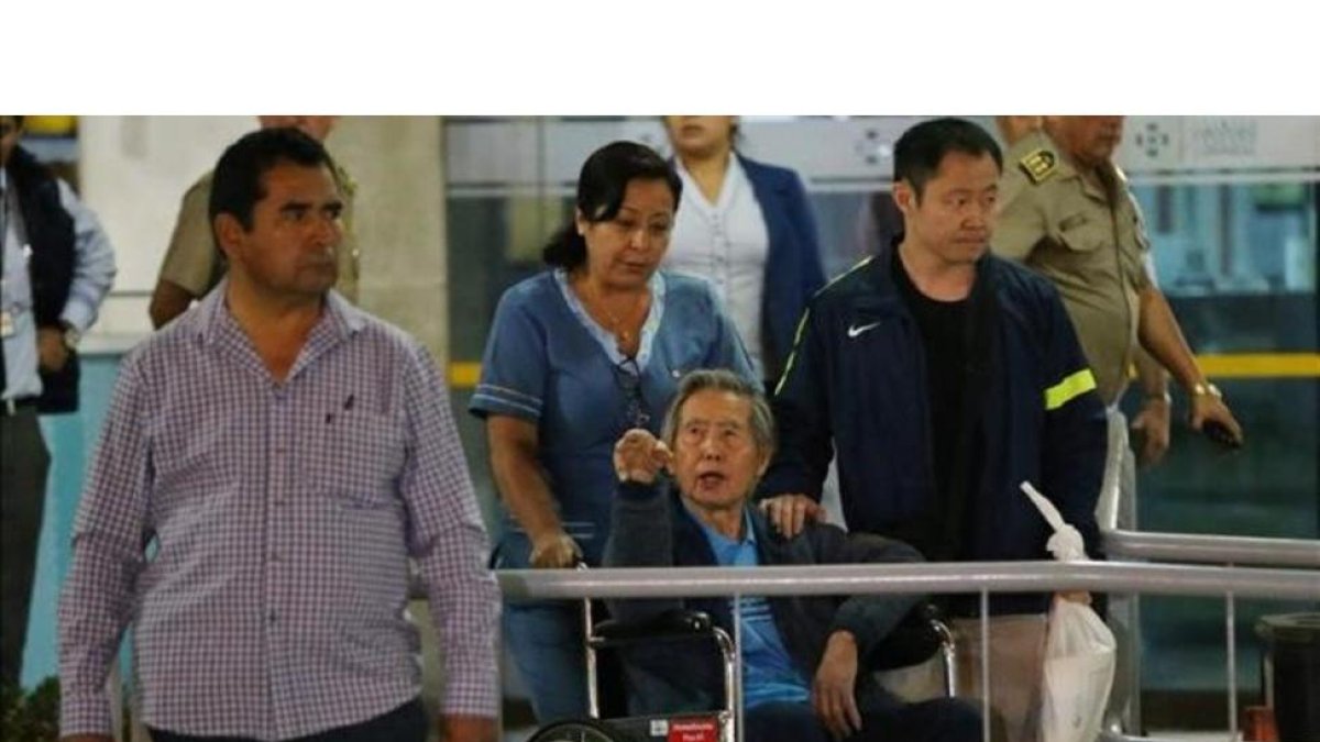 El expresidente peruano Alberto Fujimori saluda a sus simpatizantes junto a su hijo, el congresista Kenji Fujimori, al salir de la Clínica Centenario en Lima.-LUKA GONZALES