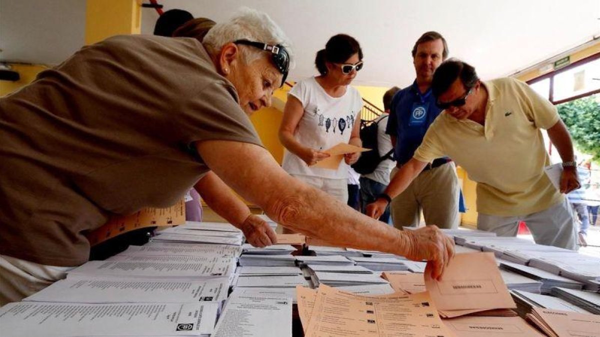 Votantes eligen papeletas en un colegio electoral de Madrid en las elecciones generales del 26 de junio de 2016.-JUAN MANUEL PRATS