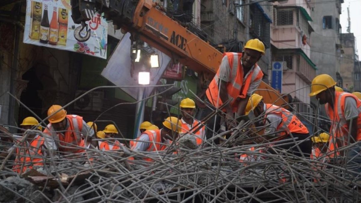 Trabajadores de emergencias indios en las tareas de rescate tras el derrumbamiento de un puente en Calcuta, India.-DIBYANGSHU SARKAR