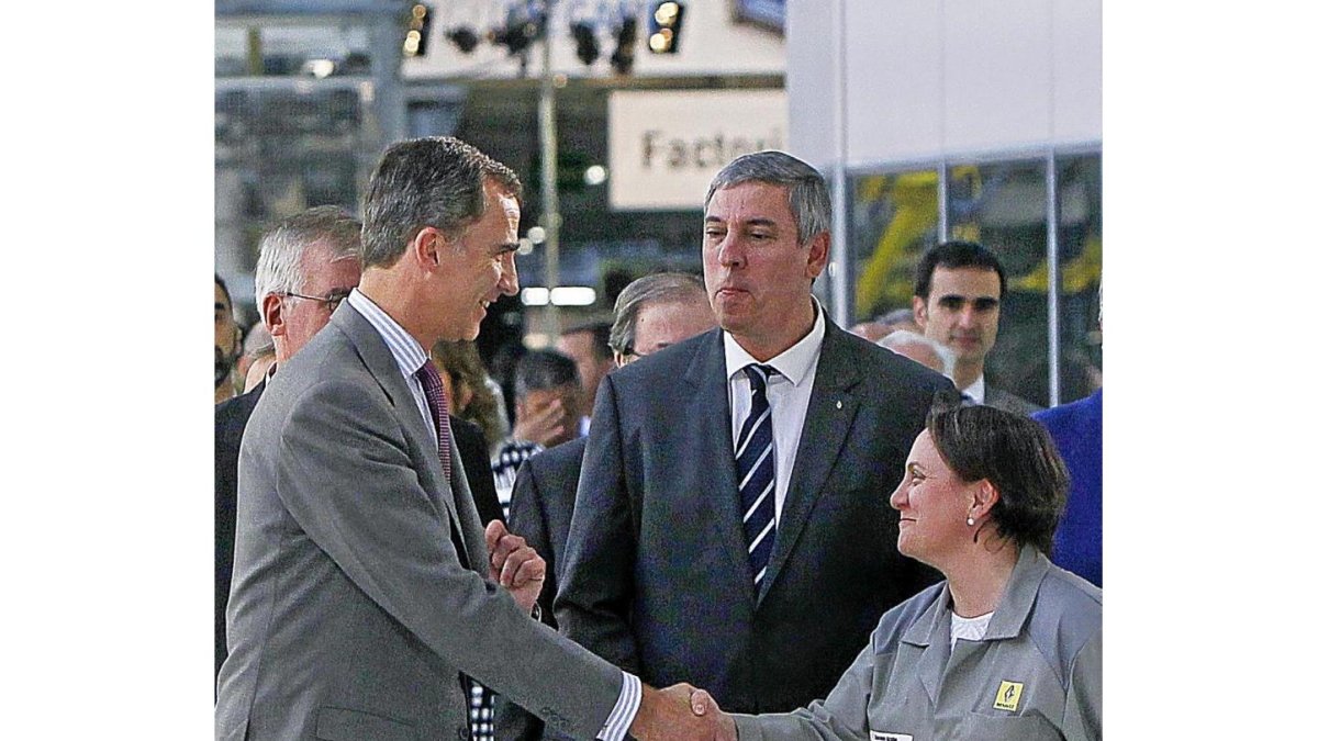 El monarca saluda a una trabajadora, en presencia de José Vicente de los Mozos durante su visita a la planta de Renault en Palencia.-J. M. LOSTAU