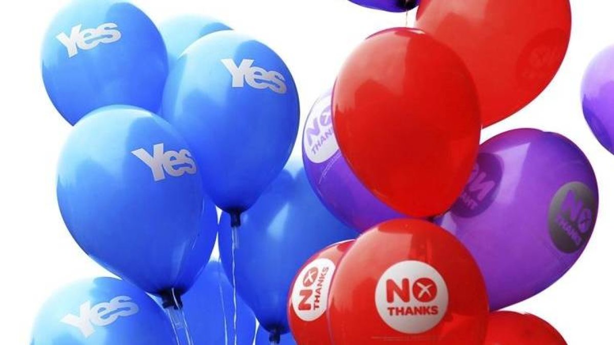 Partidarios del Sí y del No sujetan globos con distintos mensajes de cara al referéndum en Glasgow, ayer.-Foto: EFE / ANDY RAIN