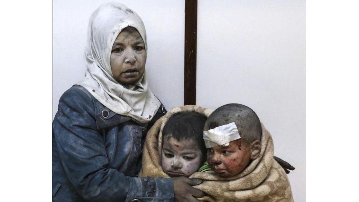 Una mujer abraza a sus hijos tras resultar todos heridos en un bombardeo en el barrio de Al Barze.-SARIEH ABU ZAID / EFE