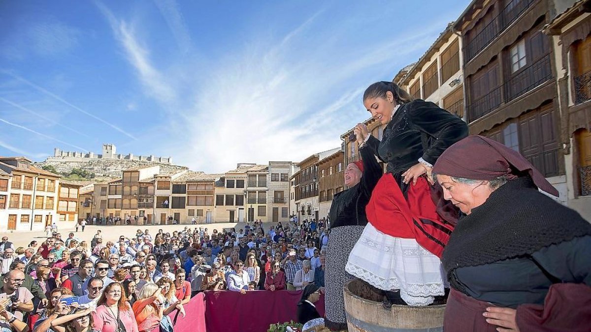 Mujeres peñafielenses realizan el tradicional pisado de uva en la Plaza del Coso de Peñafiel.-J. CASTILLO / PHOTOGENIC