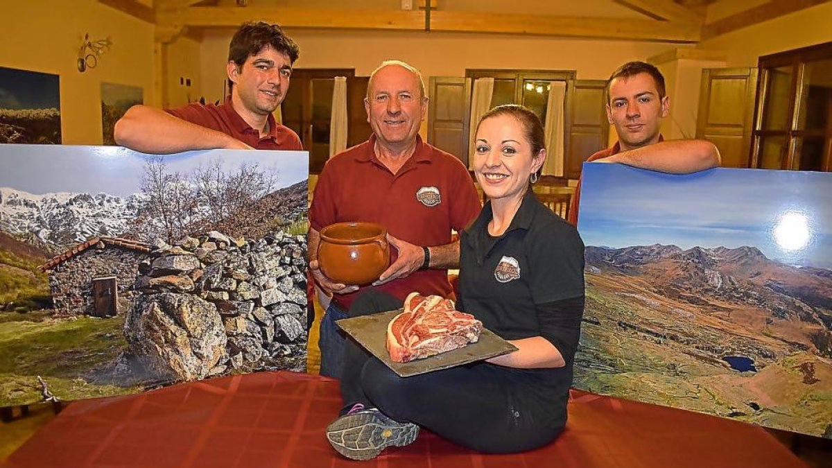 Ana, junto a Eloy (izquierda), su padre Javier y su hermano David, con las carnes rojas de la montaña y la célebre ‘olleta’.-ARGICOMUNICACIÓN