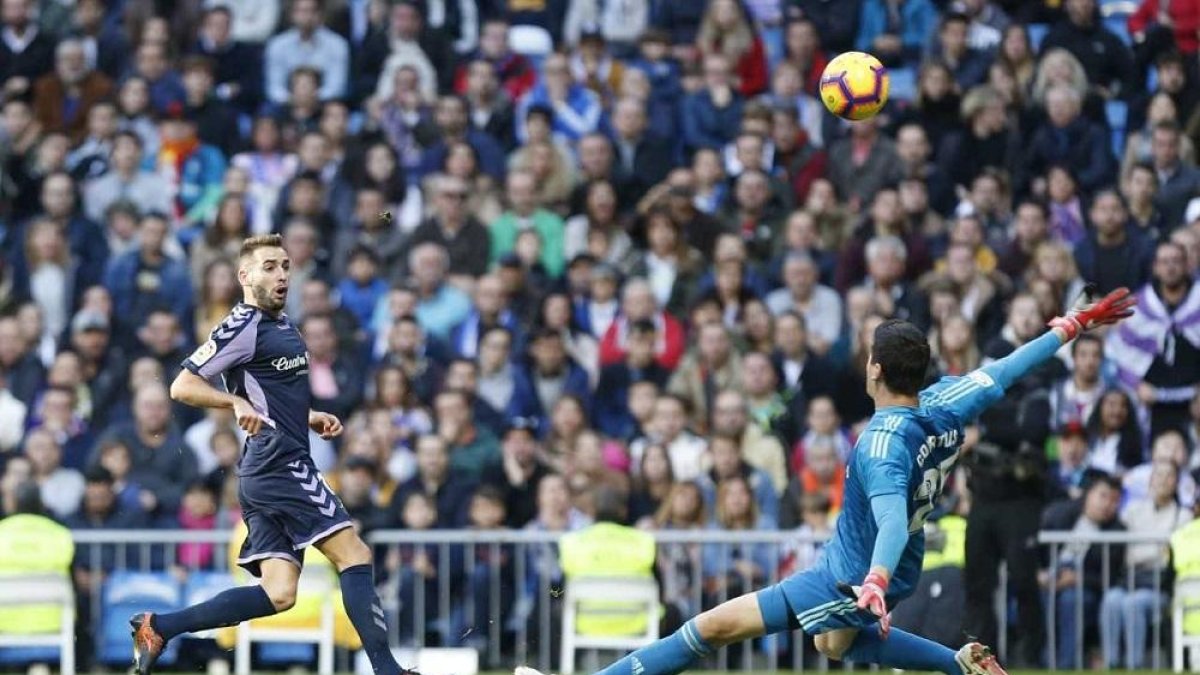 Antoñito observa la trayectoria del balón ante la salida de Courtois en la mejor ocasión del Valladolid ayer en el Bernabéu.-PHOTO-DEPORTE