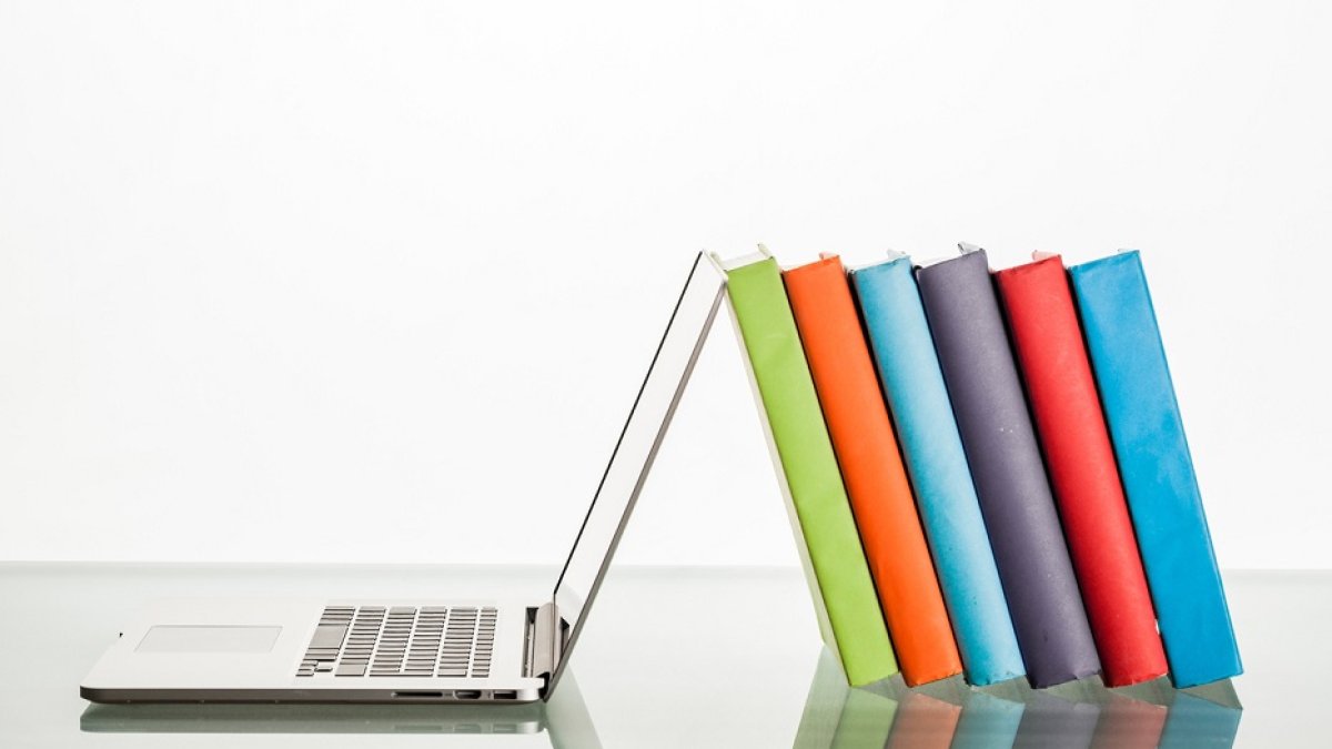 Books Leaning Against Laptop
