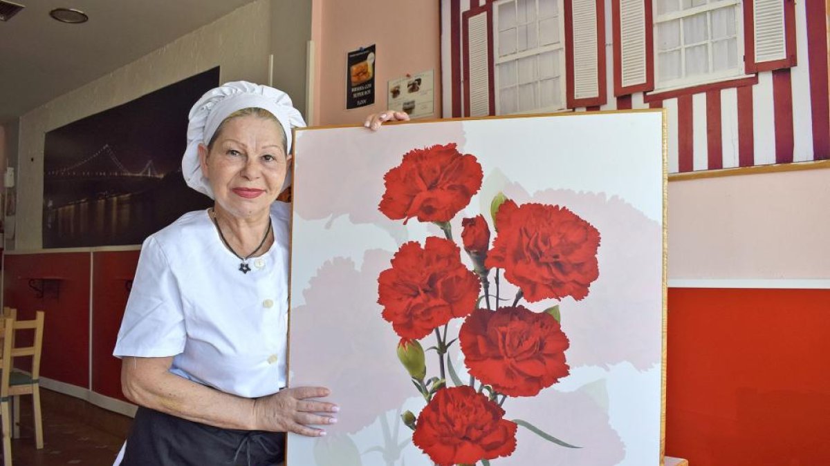 La cocinera Hortensia Eulalia dos Santos, en el comedor del Café-Fado La Portuguesa, situado en la Calle Estación de Valladolid, con una imagen de los claveles, símbolo de Portugal y también de su restaurante.-ARGICOMUNICACIÓN