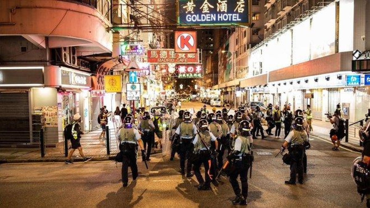 Un grupo de policías antidisturbios toma posición en una calle de Hong Kong.-