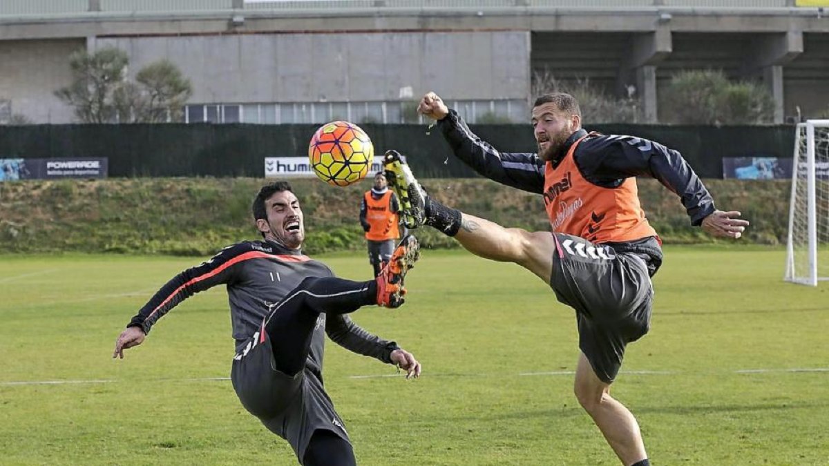 Alfaro (i) y Timor intentan llegar a un balón, durante el entrenamiento de ayer en los Anexos.-Balcaza