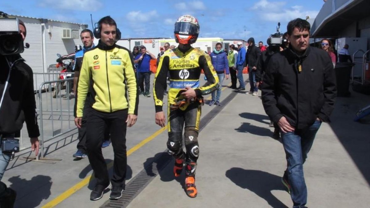 Àlex Rins, acompañado de su padre Rafa, camina hacia su box tras caerse en Australia.-EMILIO PÉREZ DE ROZAS / Enviado especial