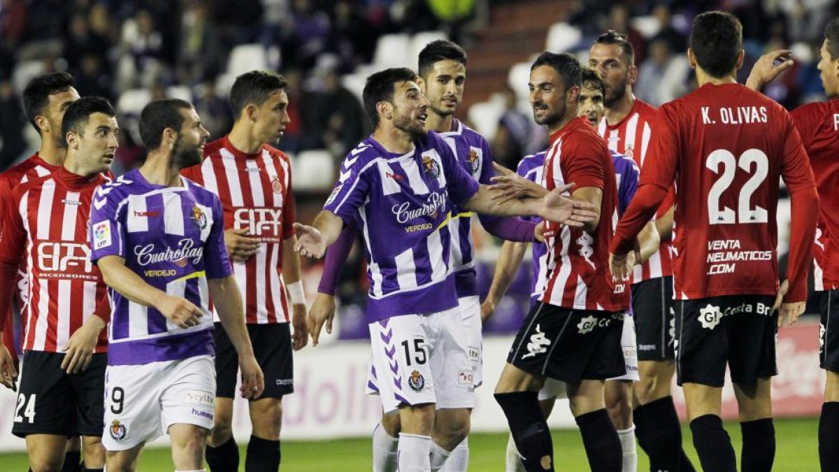 Nikos discute con jugadores del Girona durante un momento del partido.-J. M. LOSTAU