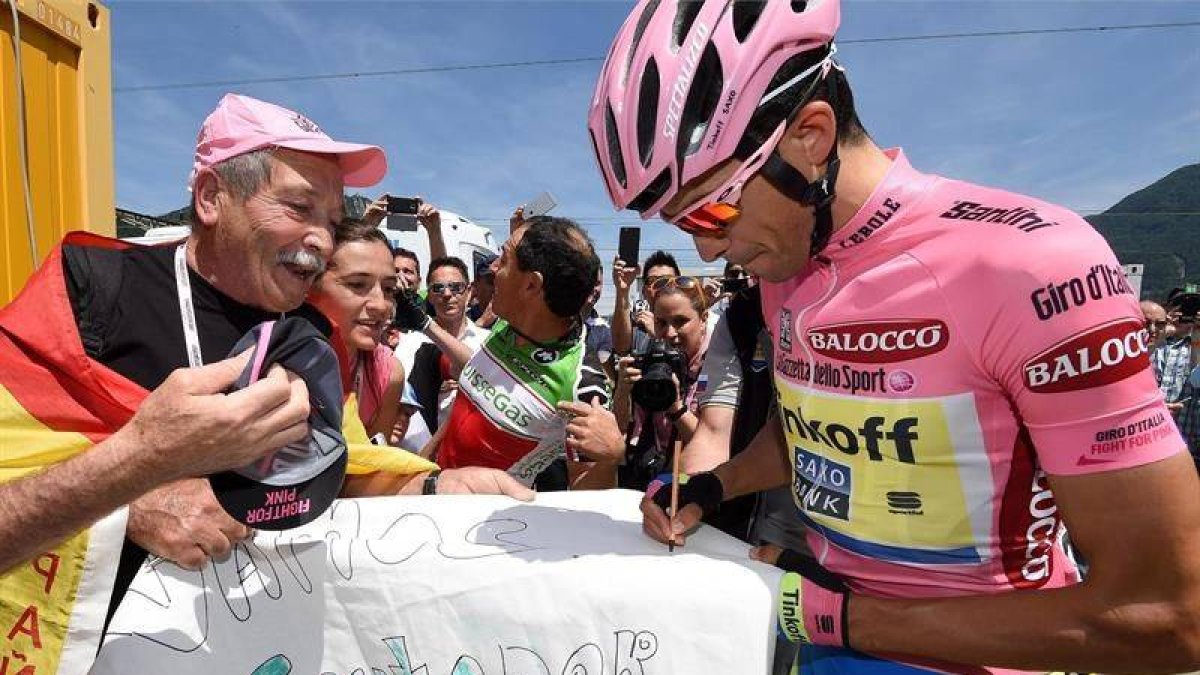 Contador firma autógrafos antes de comenzar la decimoctava etapa.-EFE
