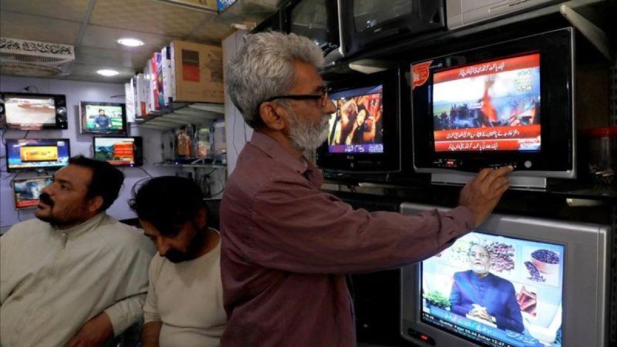 Un ciudadano pakistaní se informa tras el derribo de dos cazas indios.-AKHTAR SOOMRO (REUTERS)