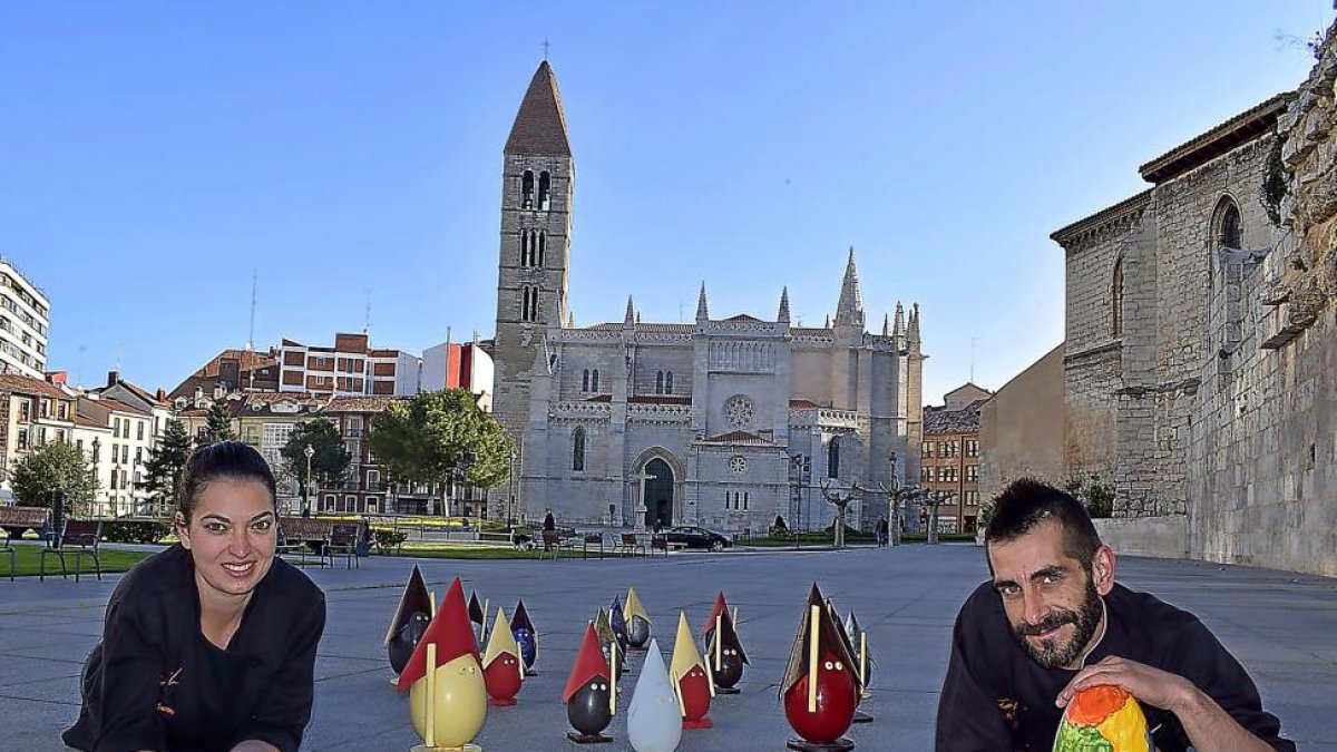 Rubén y Judit, con su colección de monas de chocolate inspiradas en la Semana Santa de Valladolid, y la iglesia de La Antigua al fondo.-ARGI