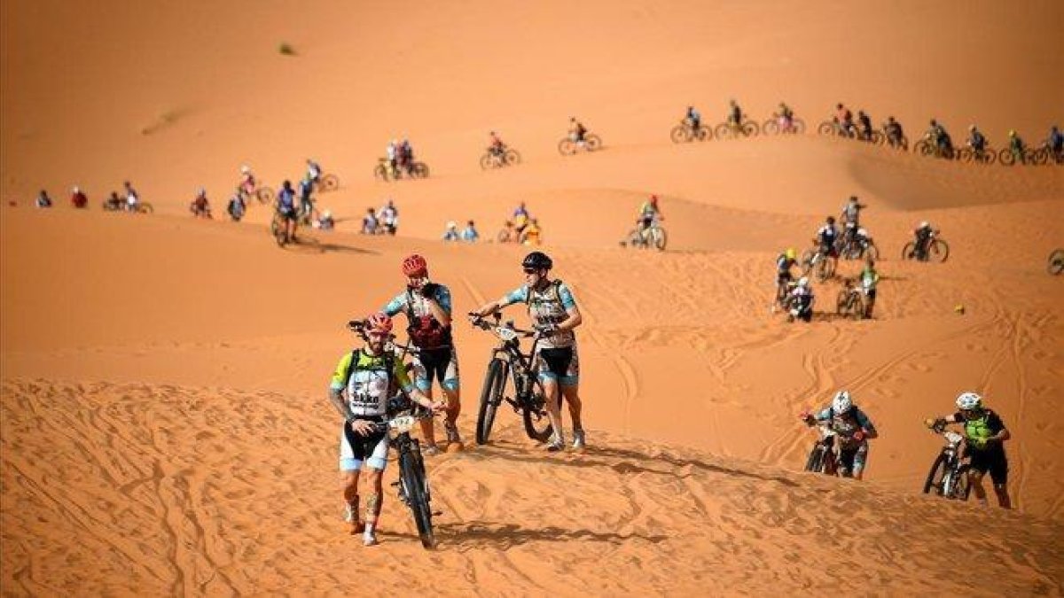 Los participantes de la Titan Desert atraviesan una zona de dunas en la primera etapa.-AFP / FRANCK FIFE