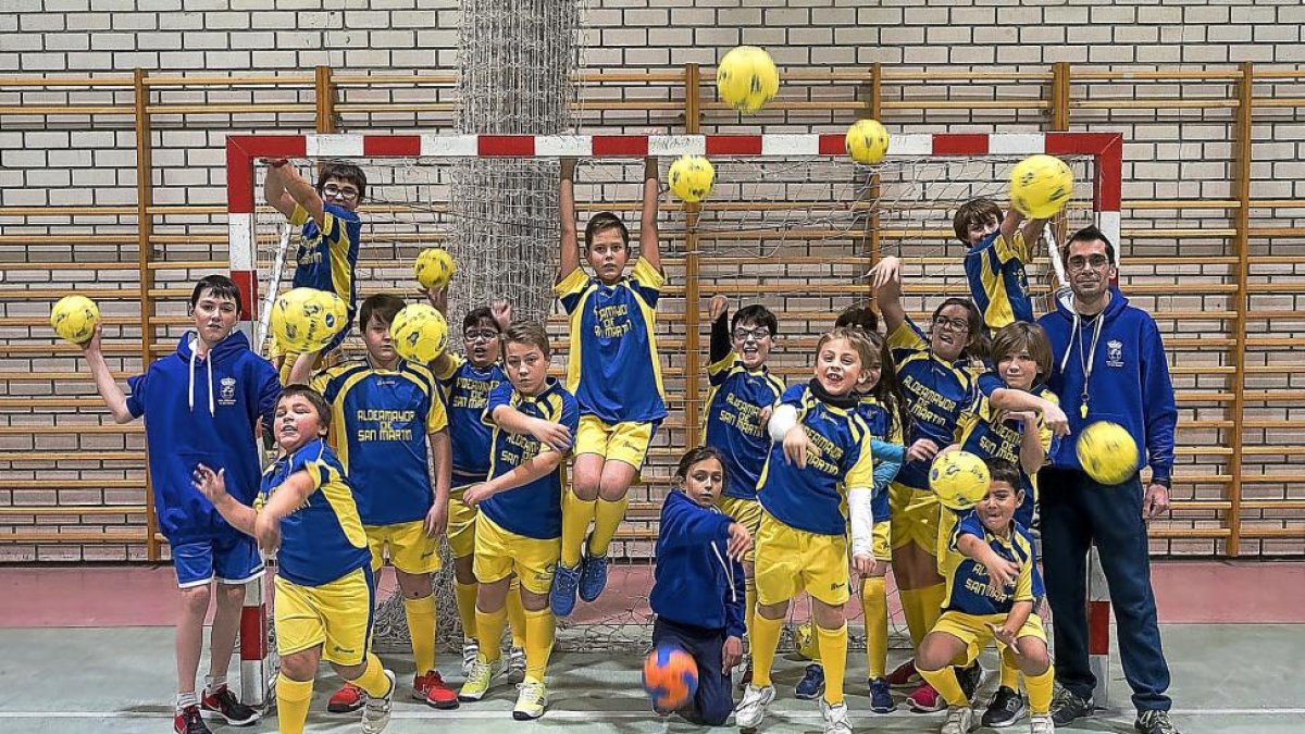 Los jugadores y jugadoras del Aldeamayor de San Martín, junto a su entrenador Kiko Villalba, lanzan balones en el polideportivo del municipio.-PABLO REQUEJO