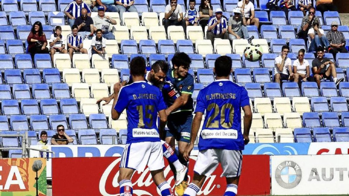 Valiente despeja ante tres jugadores del Recreativo, en su último partido como blanquivioleta.-E.M.