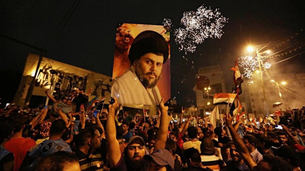 Un seguidor de Moqtada al Sadr sostiene una foto del clérigo en una concentración en la plaza Tahrir de Bagdad para celebrar el resultado electoral.-/ AP / HADI MIZBAN