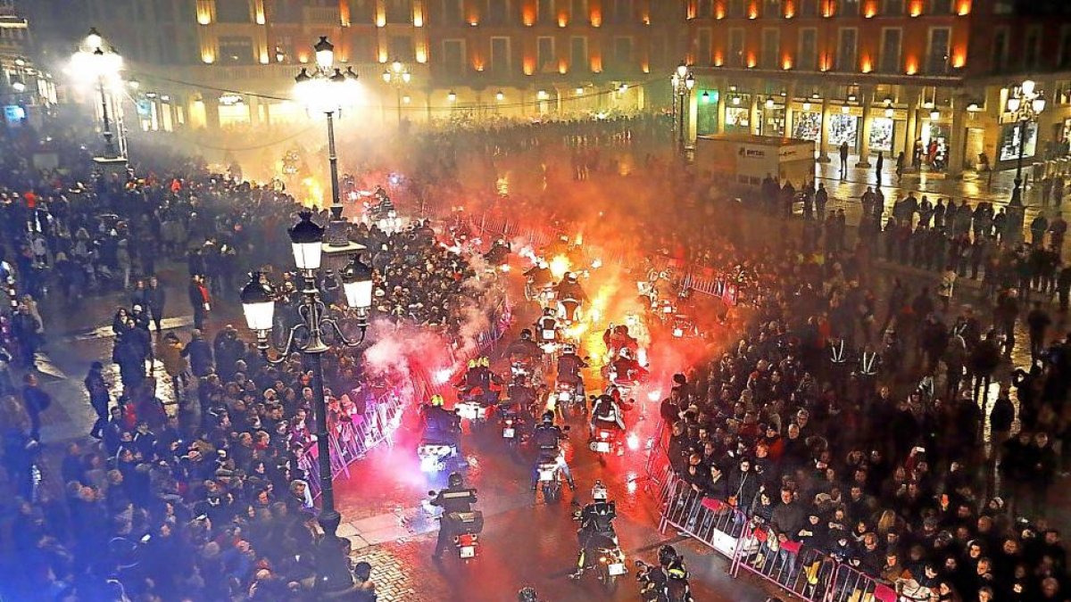 Los participantes en el desfile de las antorchas durante su recorrido por la plaza Mayor, mientras el público contempla el paso de la comitiva.-J.M. LOSTAU