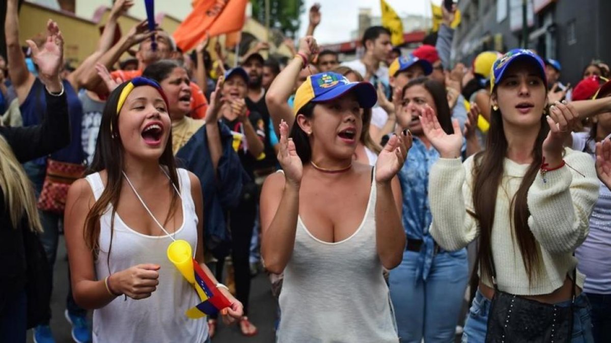 Varias jóvenes gritan consignas contra el presidente Maduro, en Los Teques (Estado de Miranda, Venezuela), este miércoles.-AFP / RONALDO SCHEMIDT