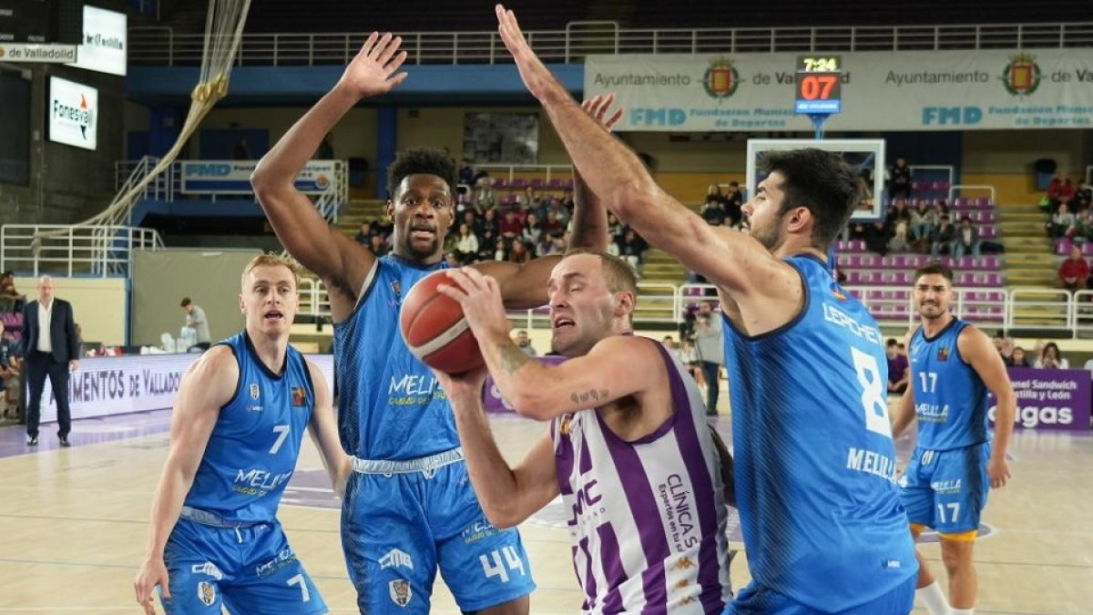 Devin Schmidt penetra entre dos jugadores del Melilla en el último partido del UEMC Real Valladolid saldado con derrota. / J. M. LOSTAU