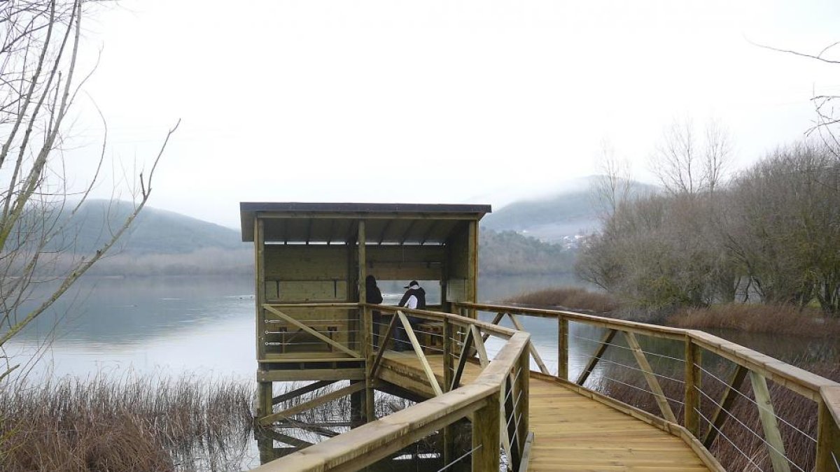 Mirador de aves en el lago Carucedo. En la página siguiente, el globo adaptado sobrevuela Segovia  y dos personas pasean por una de las sendas de Carucedo.-L.P.