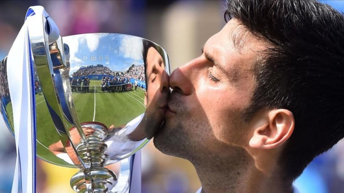 Novak Djokovic besa el trofeo del torneo de Eastbourne tras derrotar a Gaël Monfils en la final.-GLYN KIRK