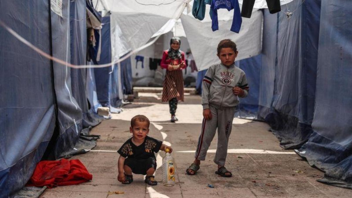 Niños desplazados desde Guta oriental, en Siria, juegan en un campo de refugiados en la ciudad de Atarib, cerca de Alepo.-MOHAMMED BADRA (EFE)