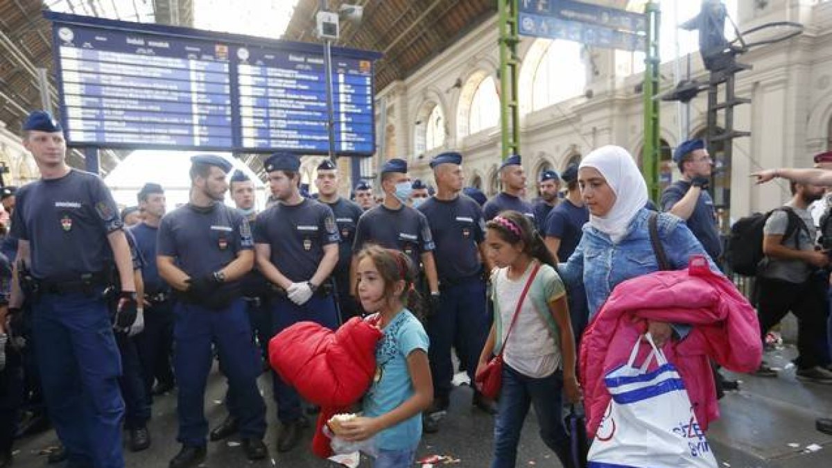 Una familia de refugiados deja la estación más importante de este de Budapest, después de que la policía la cerrara impidiédoles el paso con una valla humana.-REUTERS / LASZLO BALOGH