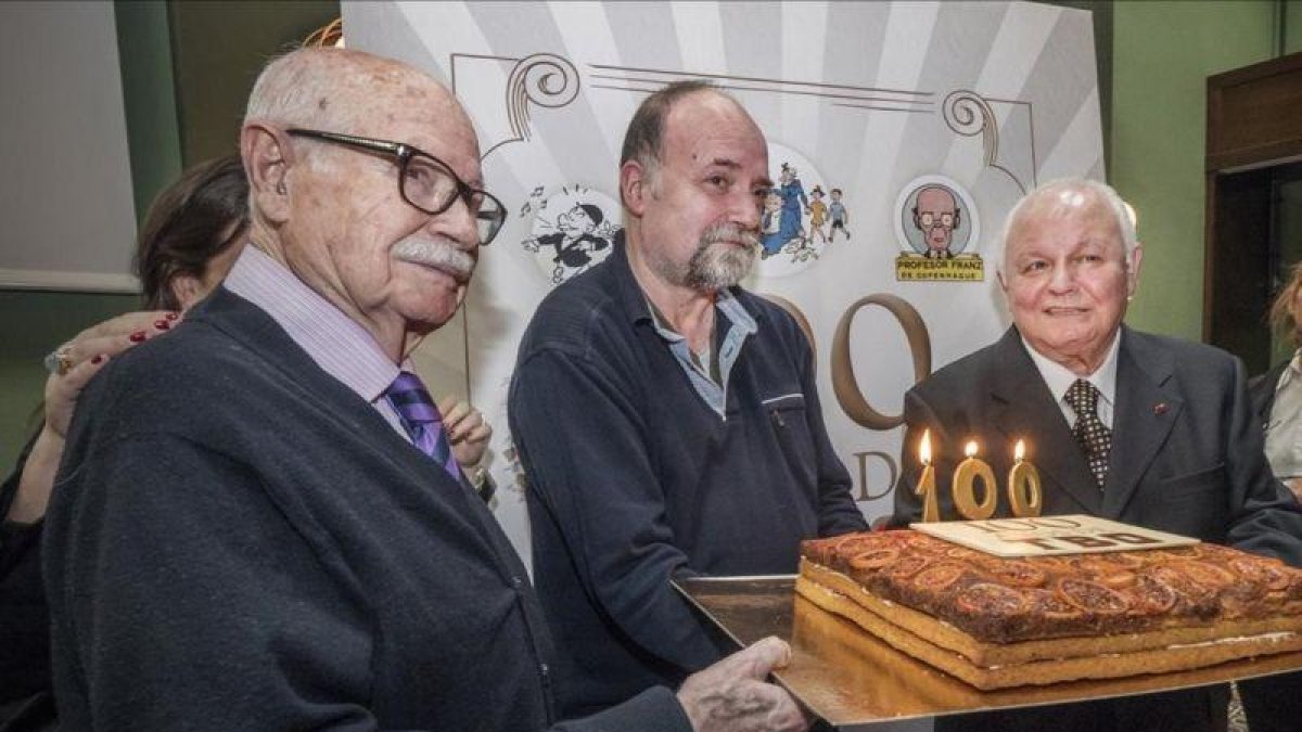 El histórico dibujante de 'TBO' Josep Maria Blanco, Antoni Guiral, autor de '100 años de TBO', y Lluís Giralt, que ha colaborado en el libro, a punto de soplar las velas del aniversario de la mítica revista de cómic.-RICARD FADRIQUE