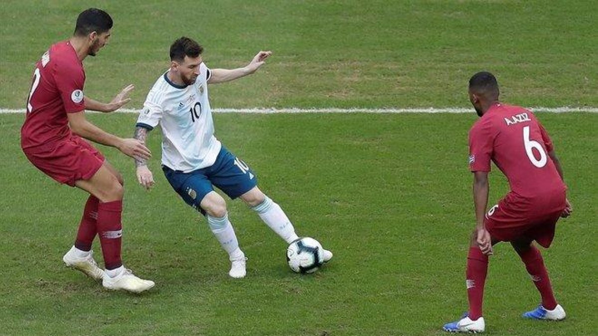 Messi controla un balón, vigilado por jugadores de Qatar.-EFE / JUAN IGNACIO RONCORONI