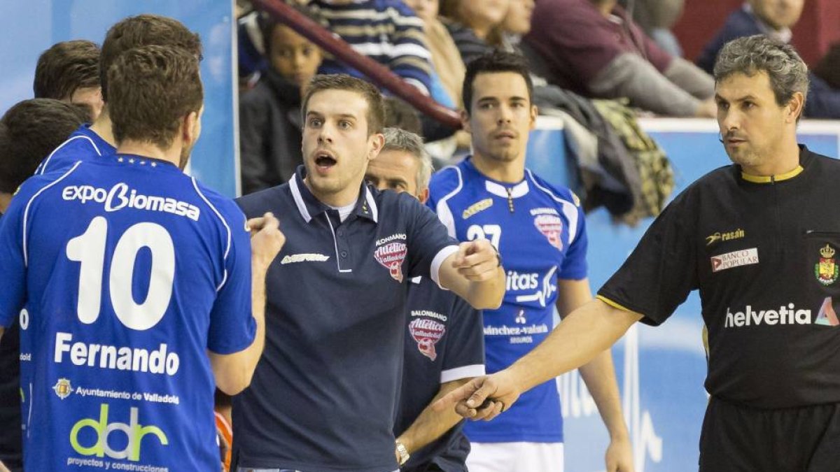 El entrendor del BM Atlético Valladolid da ordenes a Fernando en presencia del árbitro del partido-M. A. SANTOS