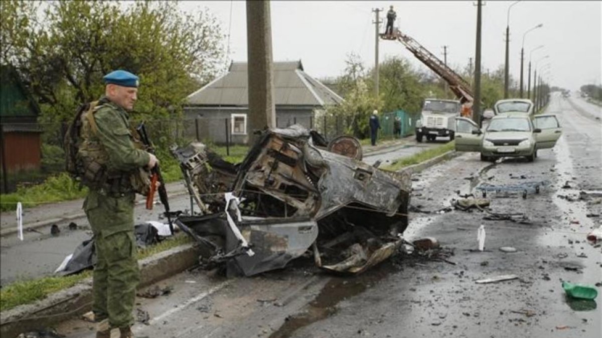 Un soldado permanece junto a un vehiculo calcinado en el lugar del ataque.-RPD / ALEXANDER ERMOCHENKO