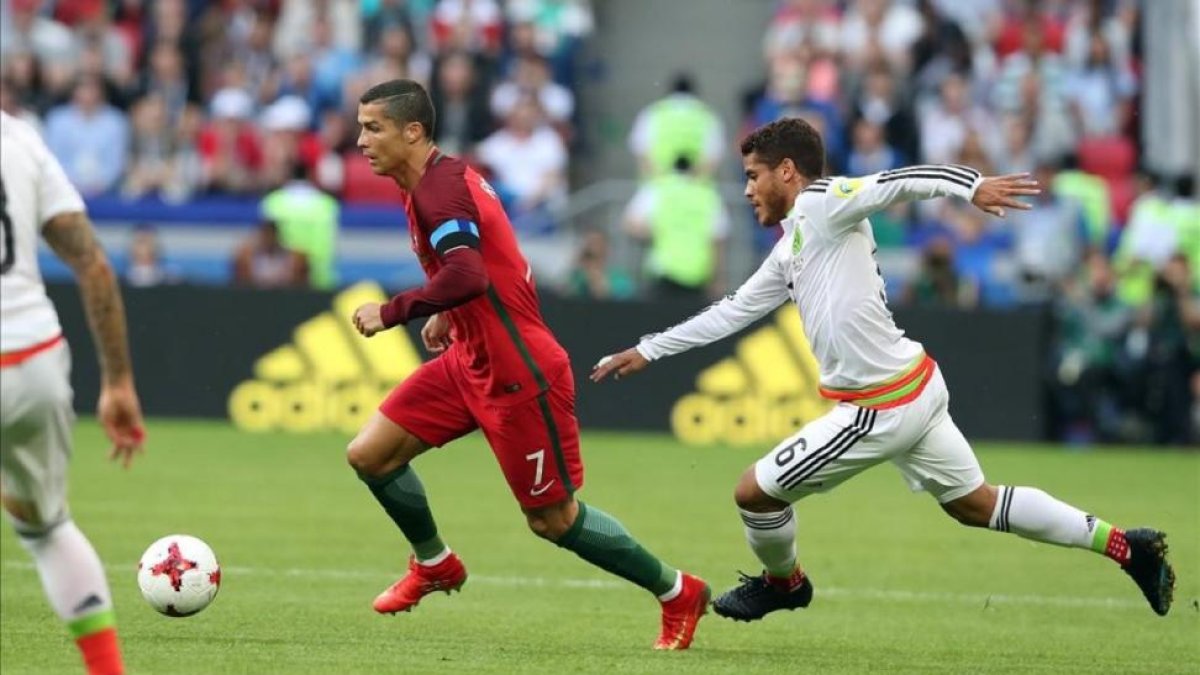 Ronaldo se va de Jonathan Dos Santos en el primer tiempo del Portugal-México.-EFE / TOLGA BOZOGLU