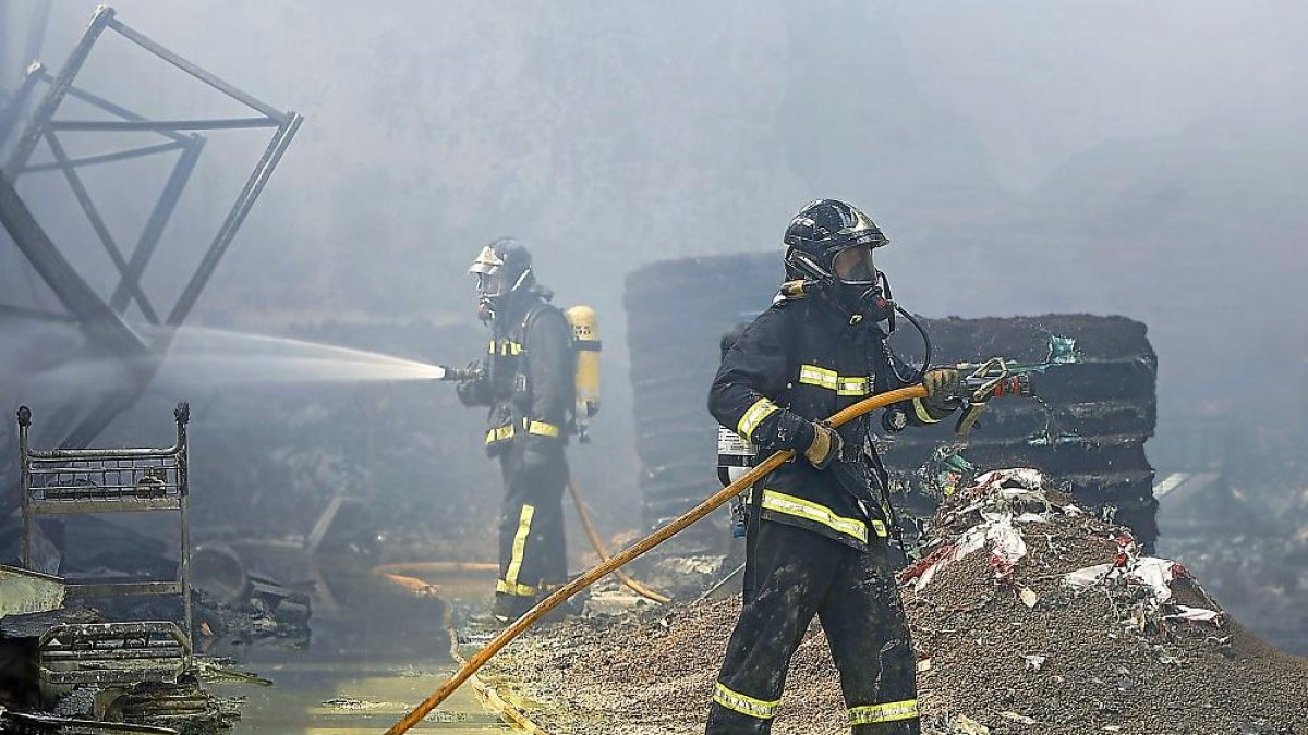 Dos agentes medioambientales trabajan en la extinción de un incendio en Peñafiel, en una imagen de archivo.-J.M. LOSTAU